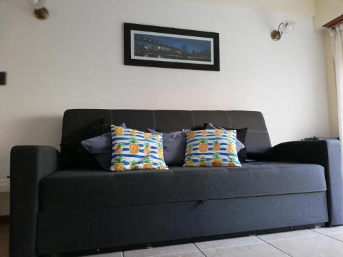 un sofá negro con almohadas en la sala de estar en Departamento Víctoria en Mar del Plata