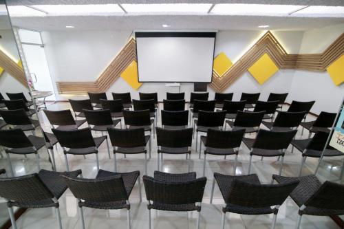 a conference room with chairs and a screen at Pousada Capital das Águas in Maceió