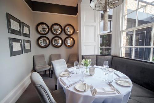 a dining room with a white table and chairs at Poets House in Ely