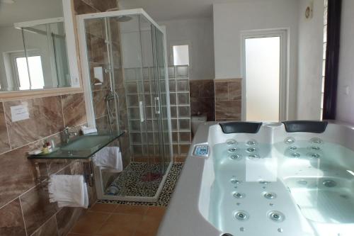 a bathroom with a bath tub and a sink at Pensión Isla - Couples Only in Casas de Cuadra