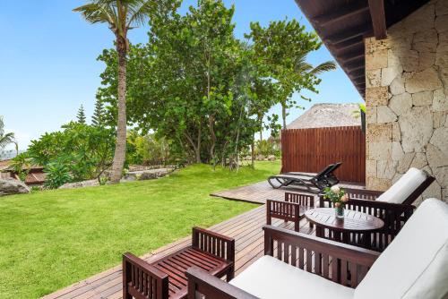 a wooden deck with chairs and a table and grass at Sanctuary Cap Cana, a Luxury Collection Resort, Dominican Republic, Adult All-Inclusive in Punta Cana