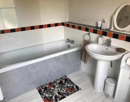 a bathroom with a tub and a sink and a toilet at Lovely Terraced 2-Bed House (near Hinksey Park) in Oxford