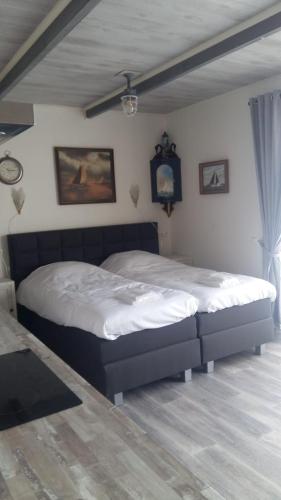 a bedroom with a large bed in a room at Appartementen De Helling 44 in Heeg
