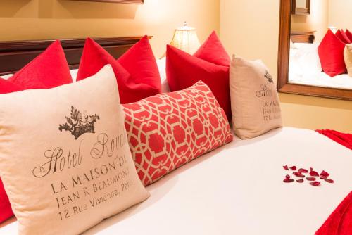 a bed with red pillows and a mirror at Five Burnham Guest House in Durban