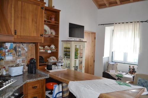 a kitchen with wooden cabinets and a counter top at Casinha de Muda da Feteira in Angra do Heroísmo