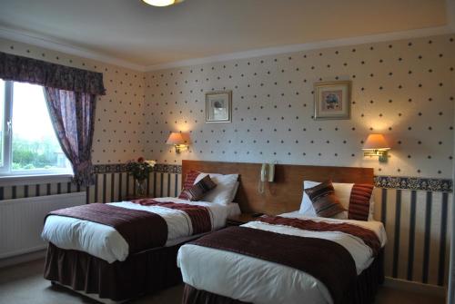 a hotel room with two beds and a window at Willowbank Hotel in Largs