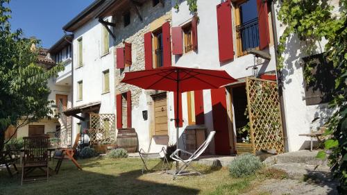 a patio with chairs and an umbrella in front of a building at Casa Cesira in Tarzo