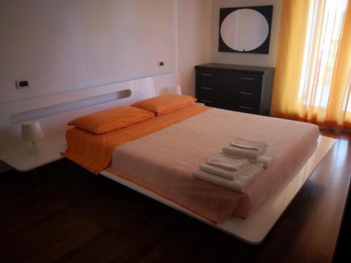 モンテジルヴァーノにあるAries Domus Montesilvanoのベッドルーム1室(オレンジのシーツと鏡付きのベッド1台付)
