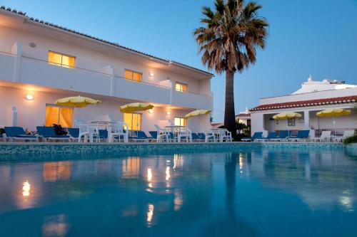 ein Hotel mit einem Pool vor einem Gebäude in der Unterkunft Apartamentos Turísticos Sollagos in Lagos