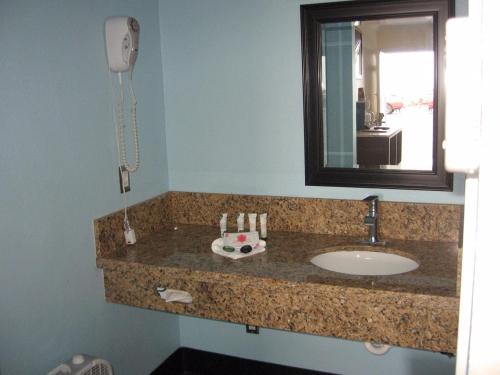 a bathroom counter with a sink and a mirror at Dolphin Cove Motel in Pismo Beach