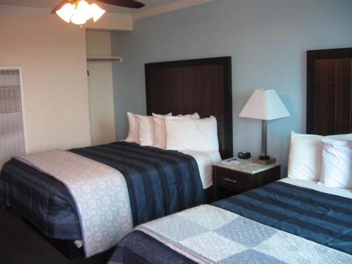 a hotel room with two beds and a lamp at Dolphin Cove Motel in Pismo Beach