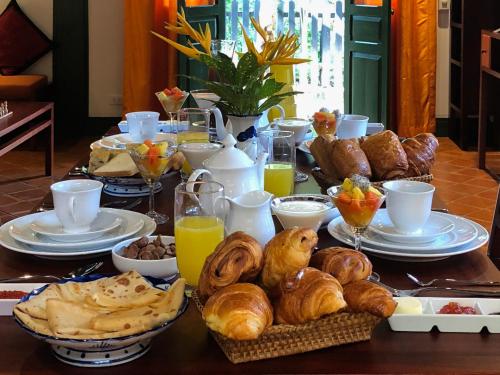 a breakfast table with croissants and other breakfast foods at Maison Houng Chanh - Luang prabang in Luang Prabang