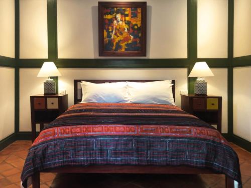 a bedroom with a large bed with two night stands at Maison Houng Chanh - Luang prabang in Luang Prabang