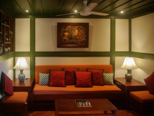 a living room with a couch and two tables at Maison Houng Chanh - Luang prabang in Luang Prabang