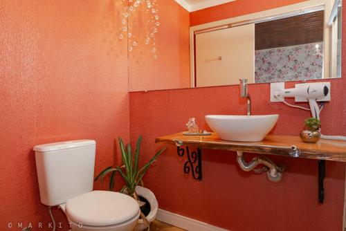 a bathroom with a white toilet and a sink at Pousada Requinte Serrano in Urubici