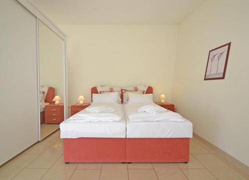1 cama roja y blanca en una habitación con espejo en Apartment Sonnenschein, en Ahlbeck