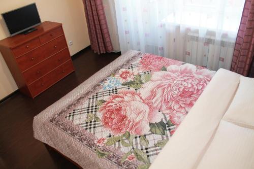 ハバロフスクにあるВойкова 8, Уютные семейные апартаменты в центре городаのベッドルーム1室(花の毛布付きのベッド1台付)