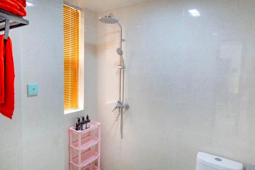 a shower in a bathroom with a pink shelf at Henan Kaifeng·Henan University· Locals Apartment 00170030 in Kaifeng