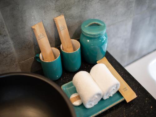 a group of toiletries in blue cups on a counter at AIRA Boutique Hoi An Hotel & Villa in Hoi An