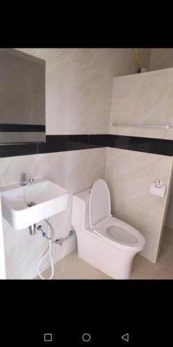 a bathroom with a white toilet and a sink at เฟรนด์แคมป์ in Khao Kho