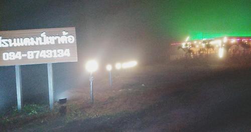 a street sign and a gas station at night at เฟรนด์แคมป์ in Khao Kho
