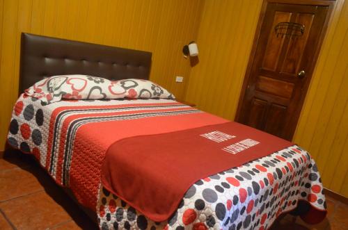 a bed in a room with a colorful blanket on it at Hostal La Casa De Rodrigo in Baeza