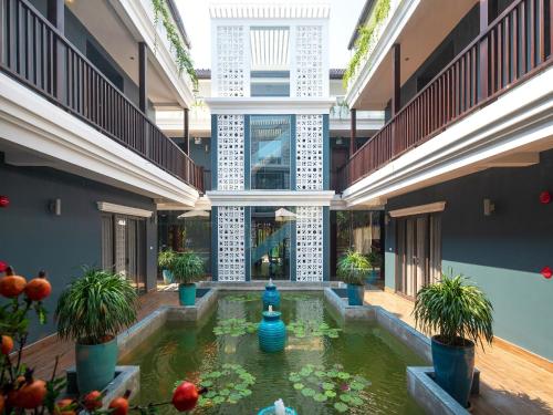 a courtyard with a koi pond in a building at AIRA Boutique Hoi An Hotel & Villa in Hoi An