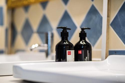 two black bottles sitting on top of a bathroom sink at Chengdu Qingyang·Kuanzhai Alley· Locals Apartment 00170590 in Chengdu