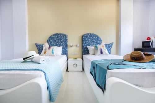 two beds in a room with blue and white at YaYa B By Briza Group in Chalong