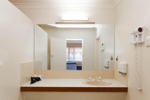 a bathroom with a sink and a mirror at Sleepwell Motel in Albany