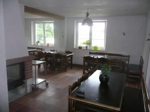 a living room with a table and chairs and a television at Penzion Venkoff in Sázava
