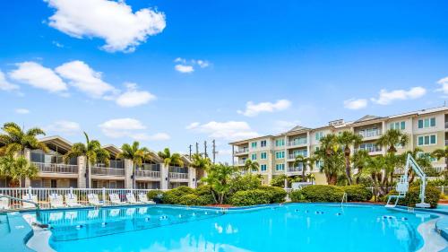 vistas a la piscina del complejo, con palmeras y apartamentos en condominio en Best Western Plus Yacht Harbor Inn en Dunedin