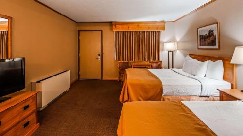 a hotel room with two beds and a flat screen tv at Deadwood Miners Hotel & Restaurant in Deadwood