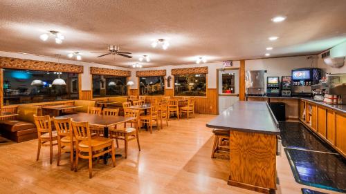 a restaurant with wooden tables and chairs and a bar at Deadwood Miners Hotel & Restaurant in Deadwood