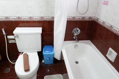 a bathroom with a toilet and a bath tub at 3BR Apartment at Sudirman Condominum Tower By Travelio in Jakarta