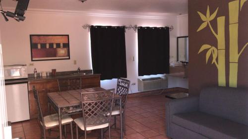 eine Küche und ein Wohnzimmer mit einem Tisch und einem Sofa in der Unterkunft Hotel Colonial de Nogales in Nogales