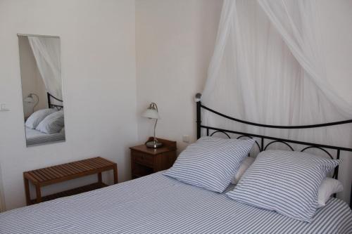 a bedroom with a bed with striped pillows and a mirror at Hôtel Le Clos des Pins in Six-Fours-les-Plages