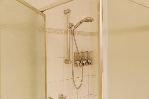 a shower with a shower head in a bathroom at Isle of Serenity Charming House in Keysborough