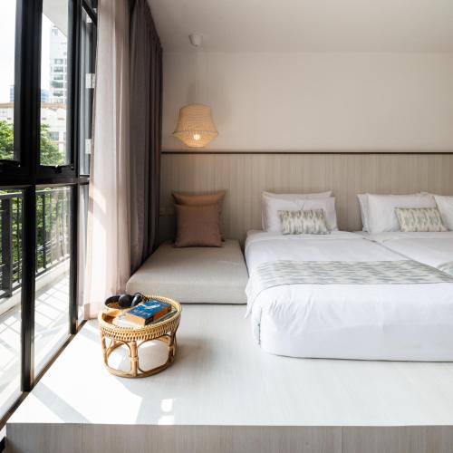 a hotel room with two beds and a window at Warm Window Silom in Bangkok