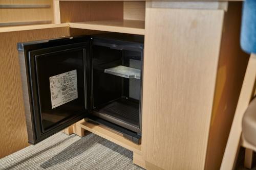 a small refrigerator in a cabinet in a room at The Royal Park Hotel Hiroshima Riverside in Hiroshima