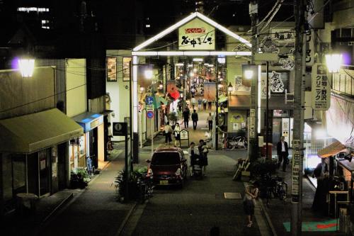a city street at night with a car parked on the street at Alo BnB 2 - Near NIPPORI, YANAKA GINZA, UENO, SENSOJI - Self check-in in Tokyo
