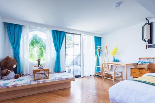 a bedroom with a teddy bear sitting on a bench next to a window at Tongli Slowlife River View Inn in Suzhou