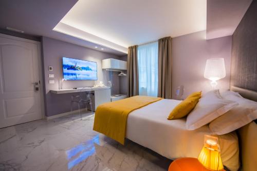 a hotel room with a large bed and a desk at Palazzo Marletta Luxury House Hotel in Catania