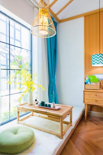 a living room with a table and a large window at Tongli Slowlife River View Inn in Suzhou