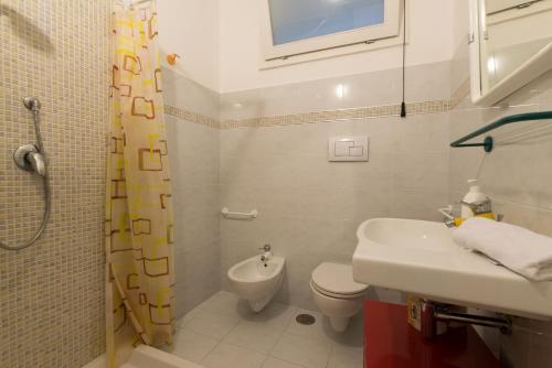 La salle de bains est pourvue d'un lavabo, de toilettes et d'une douche. dans l'établissement Brezza di Mare - Sea Breeze, à Villanova di Ostuni