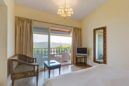 a bedroom with a bed and a mirror and a television at Ramsukh Resorts and Spa in Mahabaleshwar