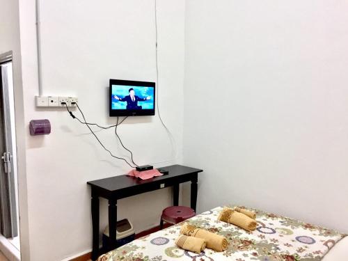 een kamer met een bed en een tv aan de muur bij Bunga Raya Guest House BALING in Baling