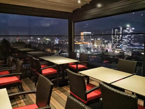 a restaurant with tables and chairs and a view of the city at Aparthotel Centar Sarajevo in Sarajevo
