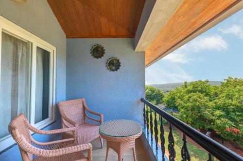 a porch with two chairs and a table on a balcony at Ramsukh Resorts and Spa in Mahabaleshwar