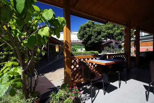 a patio with a wooden table and chairs and a tree at Jasmine Orange B&B in Jian